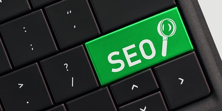 Green keyboard key labelled "SEO" with a magnifying glass icon, symbolising search engine optimisation in digital marketing.