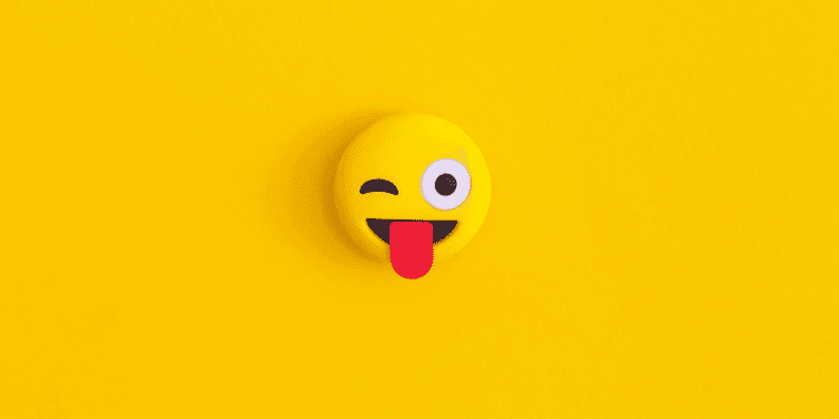 Emoji with a winking eye and tongue sticking out on a bright yellow background, symbolising playful communication in social media marketing.