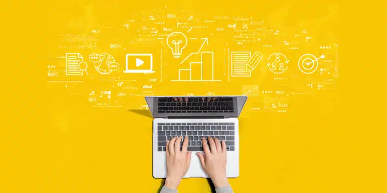 Hands typing on a laptop with digital marketing icons and graphs on a yellow background, representing content marketing and SEO strategies.