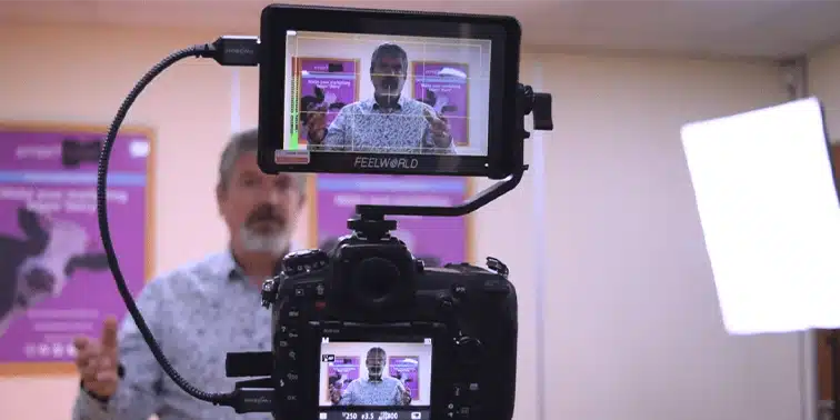 Man speaking in front of camera setup, showcasing digital marketing video testimonial production for Smart Cow agency.
