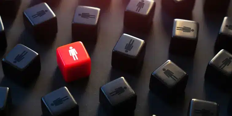 Red die with a figure standing out among black dice, symbolising differentiation in digital marketing strategies.